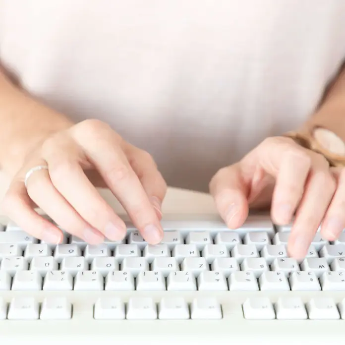 Das Symbolbild zeigt die Hände einer Frau. Sie tippt auf einer Computer-Tastatur.