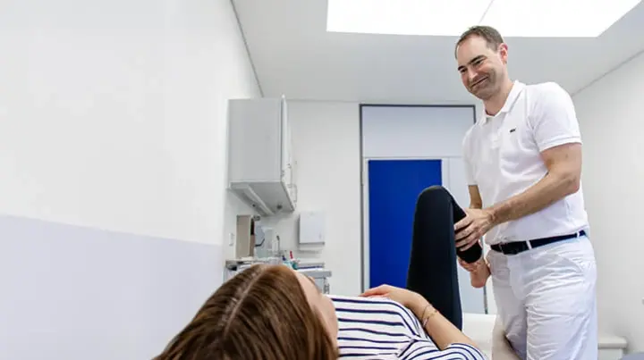 Prof. Dr. Markus Geßlein führt eine orthopädische Behandlung an einer Patientin durch.